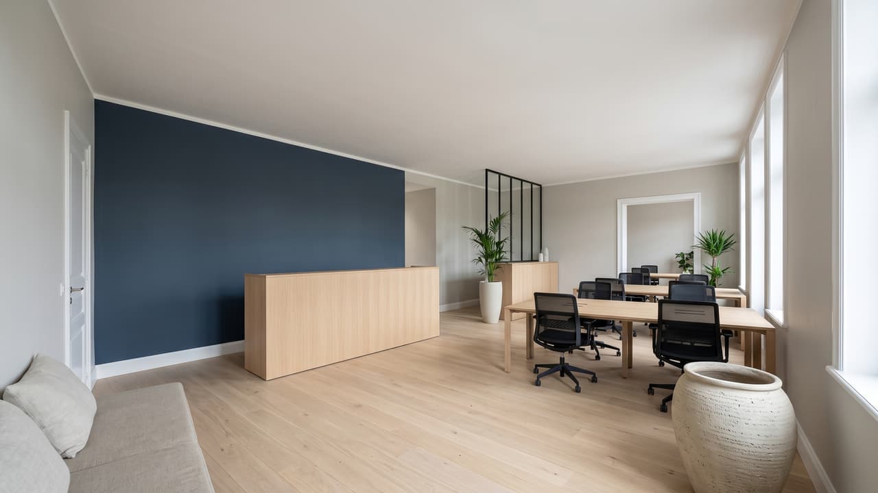 Bureau ouvert fraîchement repeint en gris perle, mobilier contemporain, lumière naturelle de grandes baies